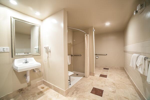 The Accessible King Room beautiful natural stone bathrooms with extra space and a roll in shower.